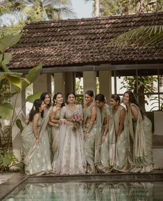 a group of women standing next to each other near a pool