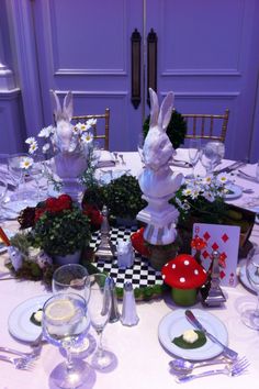 the table is set with flowers, plates and silverware for an elegant easter dinner