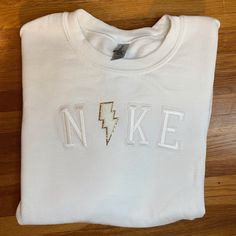 a white t - shirt with the word n k e on it and a lightning bolt