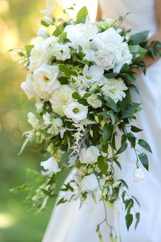 a bridal bouquet with white flowers and greenery