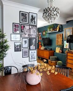 a dining room table with pictures on the wall