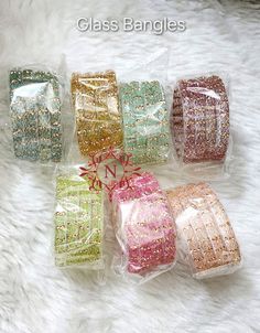 six different colored bags with bows on them sitting on a white furnishing area