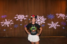 a woman standing in front of a wall with snowflakes on it