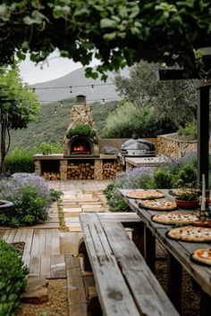 an outdoor kitchen with pizzas on the table