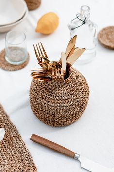 a table with place settings, utensils and napkins in woven baskets on it