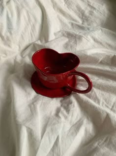 a red cup sitting on top of a white sheet