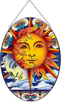 a sun and moon stained glass window hanging on a chain with an artistic design in the background