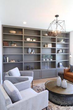 a living room with two couches and a coffee table in front of a bookshelf