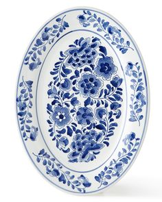 a blue and white plate with floral designs on the rim, isolated against a white background