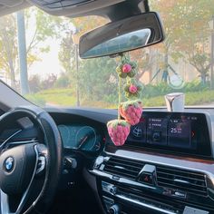 the interior of a car with flowers hanging from it's dash board and steering wheel