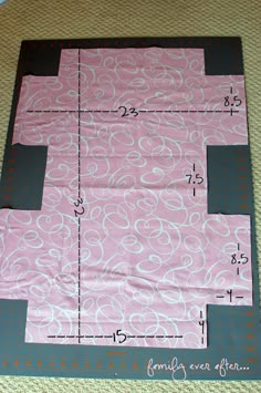 a piece of pink fabric with white circles on it, cut in half and taped to the side