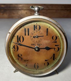 an old clock sitting on top of a table