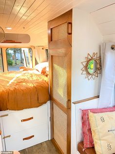 the inside of a camper with a bed and pillows