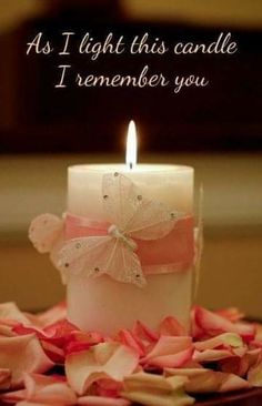 a lit candle with pink petals on the ground and a quote above it that says, as i light this candle i remember you