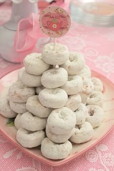 a pink plate topped with donuts on top of a table