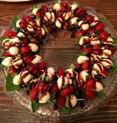 a glass plate topped with lots of food on top of a wooden table