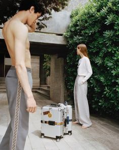 a man standing next to a woman with a suitcase