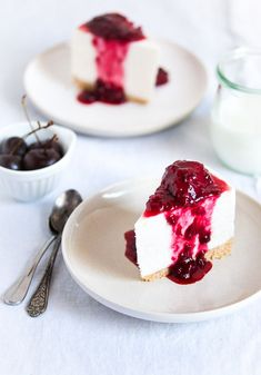 a piece of cheesecake on a plate with cherries and yogurt in the background