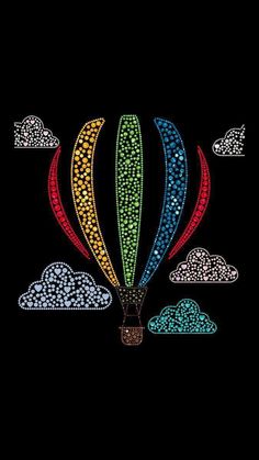 a colorful hot air balloon flying through the sky with clouds on it's side