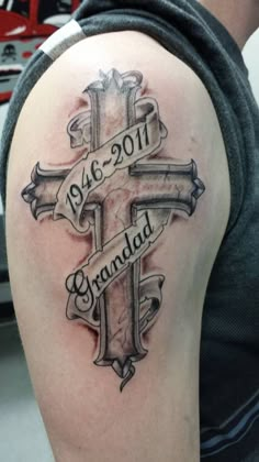 a man with a cross tattoo on his arm and the words grandad above it