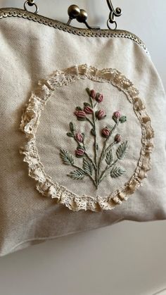 a white purse with flowers embroidered on it