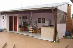 an outdoor kitchen and dining area with stairs leading up to the back door that leads into the living room