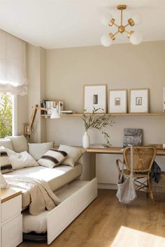 a white couch sitting in a living room next to a wooden table and chair on top of a hard wood floor