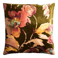 a green and pink floral pillow on a white background