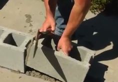 a man is working on cement blocks with a pair of tongs in his hand