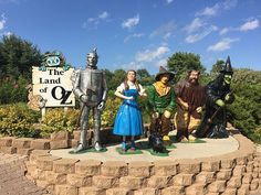 the wizard and his friends are posing in front of the sign for the land of oz