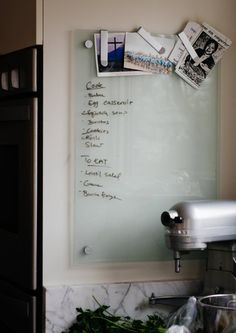 a glass board with writing on it next to a blender and other kitchen items