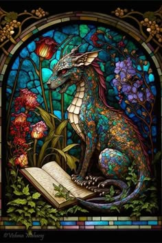 a stained glass window with a dragon sitting on an open book in front of flowers