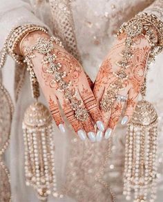 a woman's hands with hennap and jewels on them, all covered in pearls