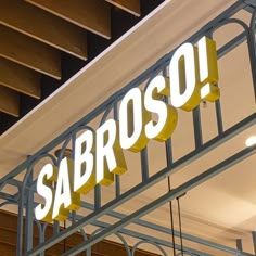 a sign that reads sabroso hanging from the ceiling above it is an awning