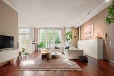 a living room filled with furniture and a flat screen tv on top of a wooden floor