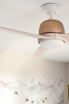 a ceiling fan in a bedroom with marble walls