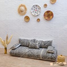 a couch sitting on top of a hard wood floor next to a wall mounted clock