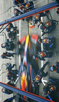 an aerial view of a red bull racing car in the pit at a race track