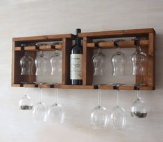 several wine glasses are hanging from a wooden rack