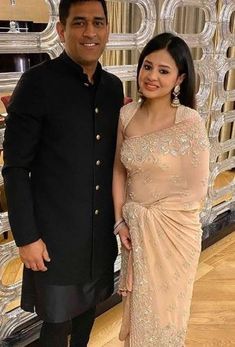 a man and woman standing next to each other in formal dress clothes posing for the camera