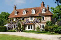 a large brick house with purple flowers on it