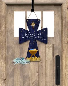 a door hanger with a cross on it that says, for unto us a child is born