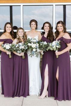 the bride and her bridesmaids pose with their bouquets in front of a window