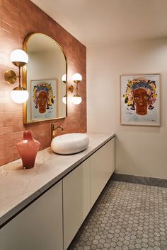 a bathroom with two sinks and a mirror on the wall next to it is tiled flooring