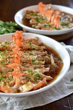 two white bowls filled with food on top of a table