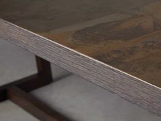 a close up view of a table with wood grained edges and metal frame legs