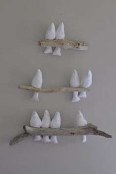 several white birds perched on branches mounted to the wall