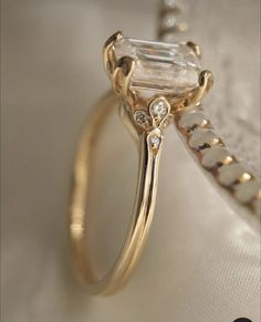 a gold ring with an emerald cut diamond