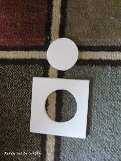 a white toilet paper holder sitting on top of a carpeted floor next to a rug