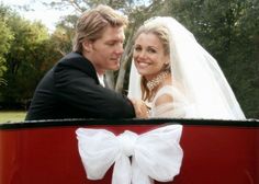 a bride and groom are sitting in a horse drawn carriage